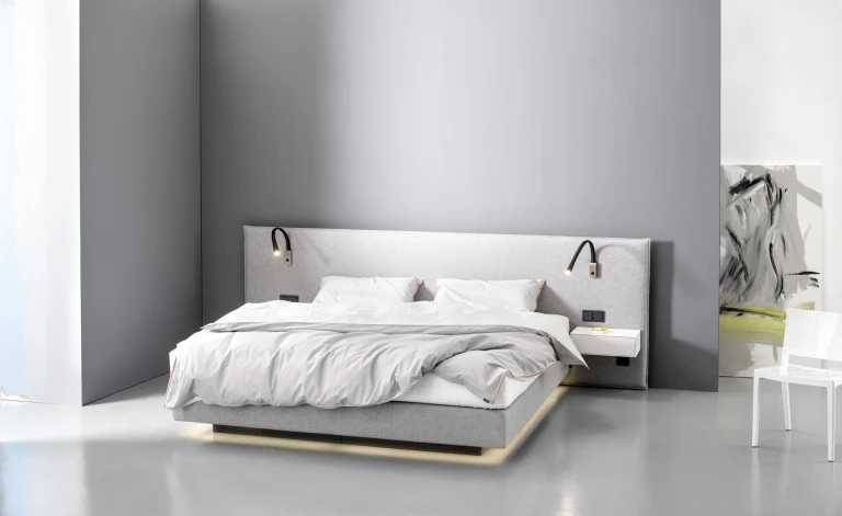 Flaches Boxspringbett mit gepolsterten Wandpaneel in flacher Kissenoptik